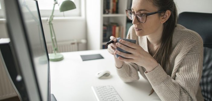 Productivity Hacks for Working From Home Women working on computer. Working from home. Drinking hot drink