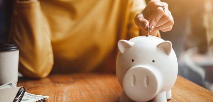 Emergency Savings 101 Putting money in white piggy bank