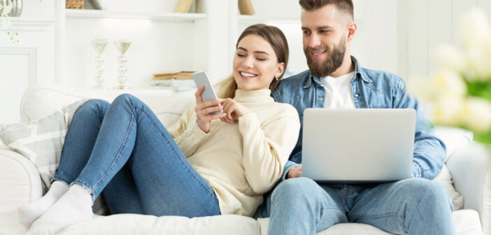 Three Of The Best: Browser Tools To Save You Money Young couple on sofa using laptop and mobile phone